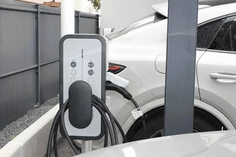 Borne de recharge sur pied branchée à une voiture électrique dans une allée privée