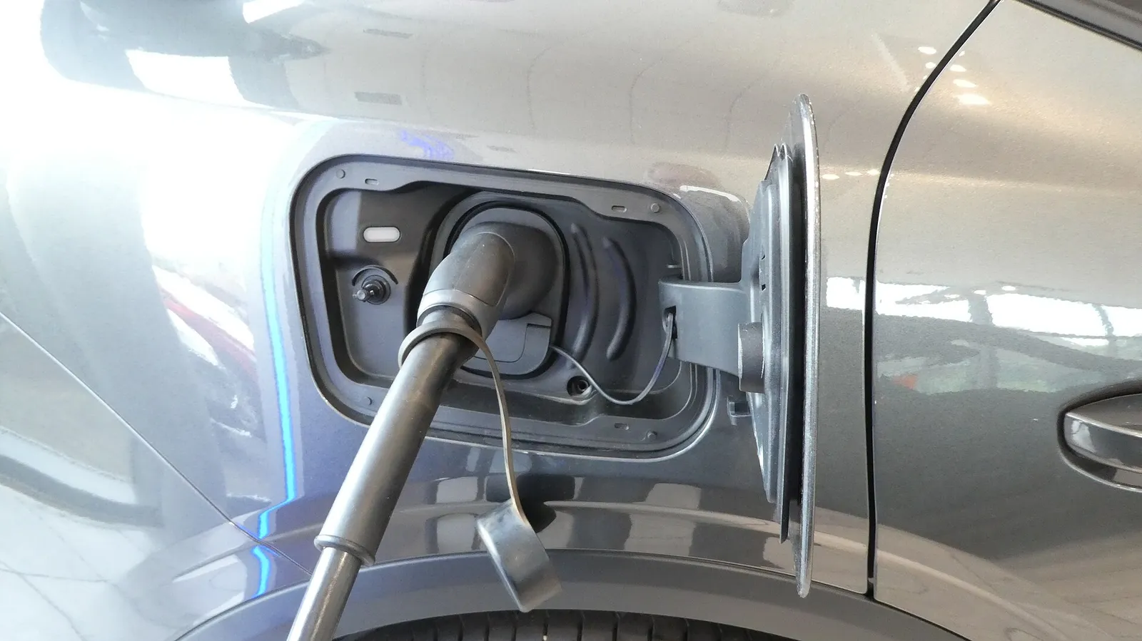 Connecteur de recharge branché dans la trappe d'une voiture électrique
