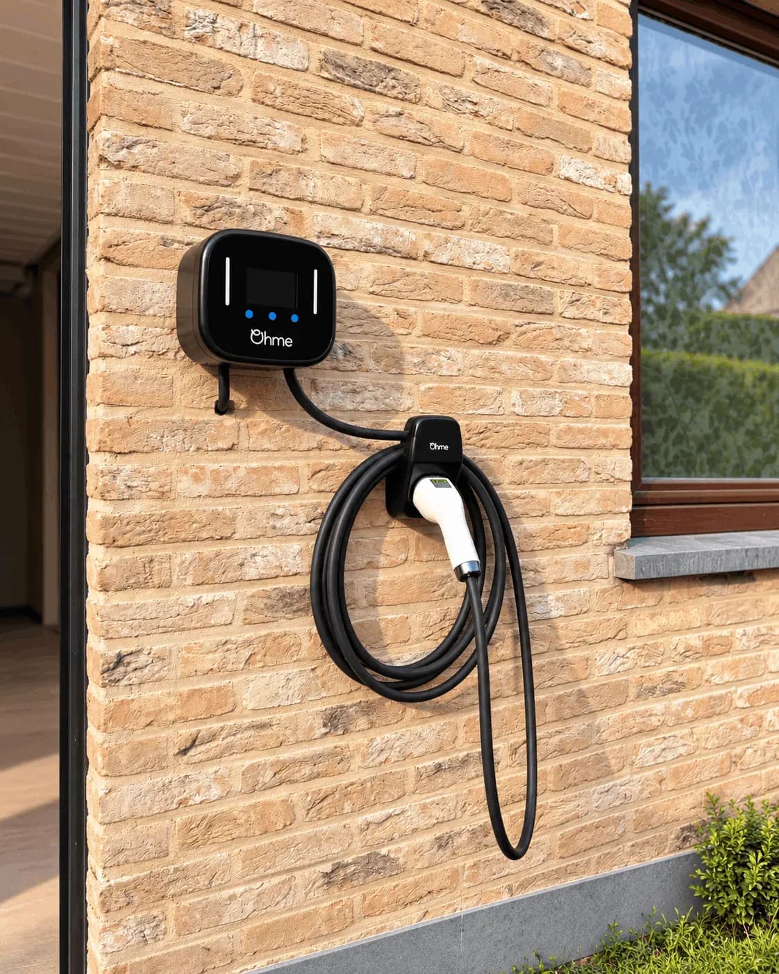 Borne Ohme murale et câble de recharge enroulé sur son support, vue de trois quarts